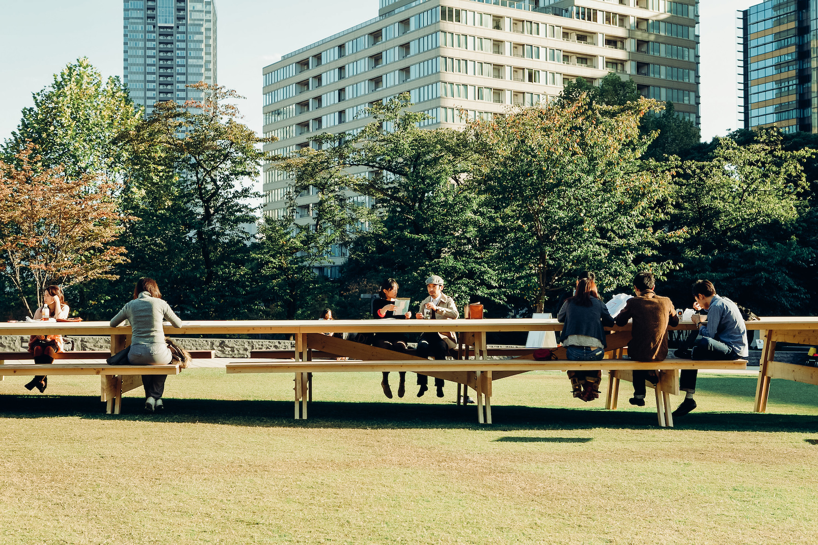 人們在戶外公園草坪使用Gulliver Table的情形
