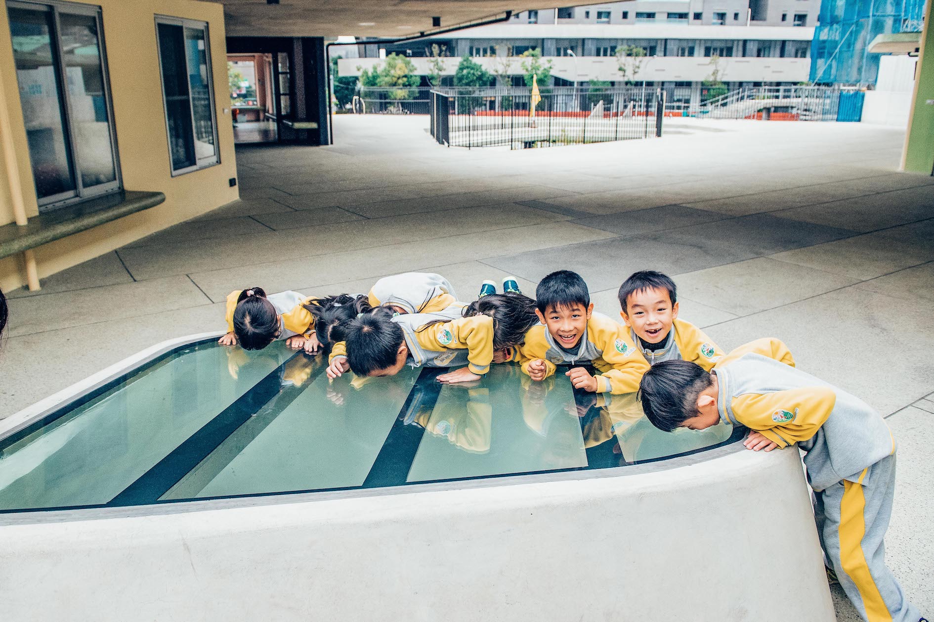 關埔國小學童趴在學校的天井玻璃罩上看下面空間。