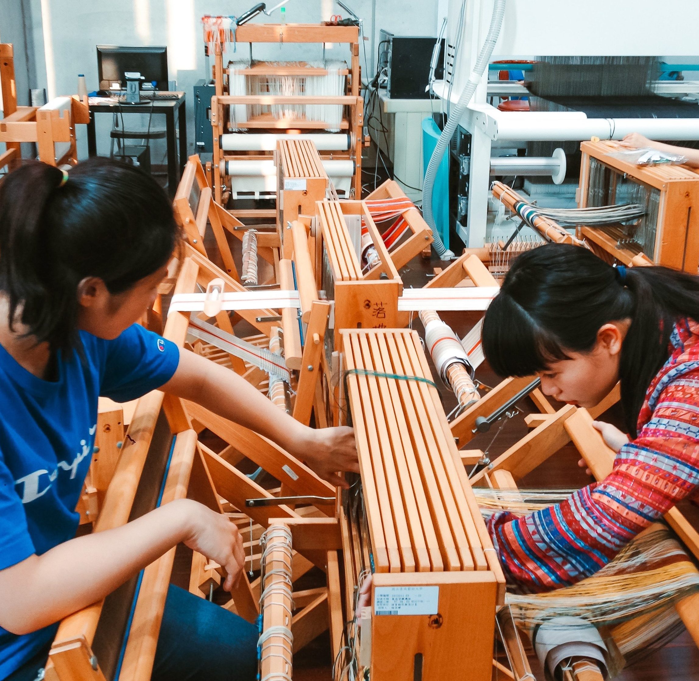 學生親自在梭織工作室的木作梭織機製作織品作品