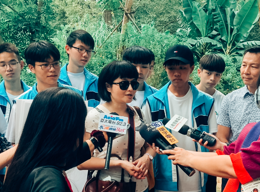 老師與志工學生參與食物森林中的記者會