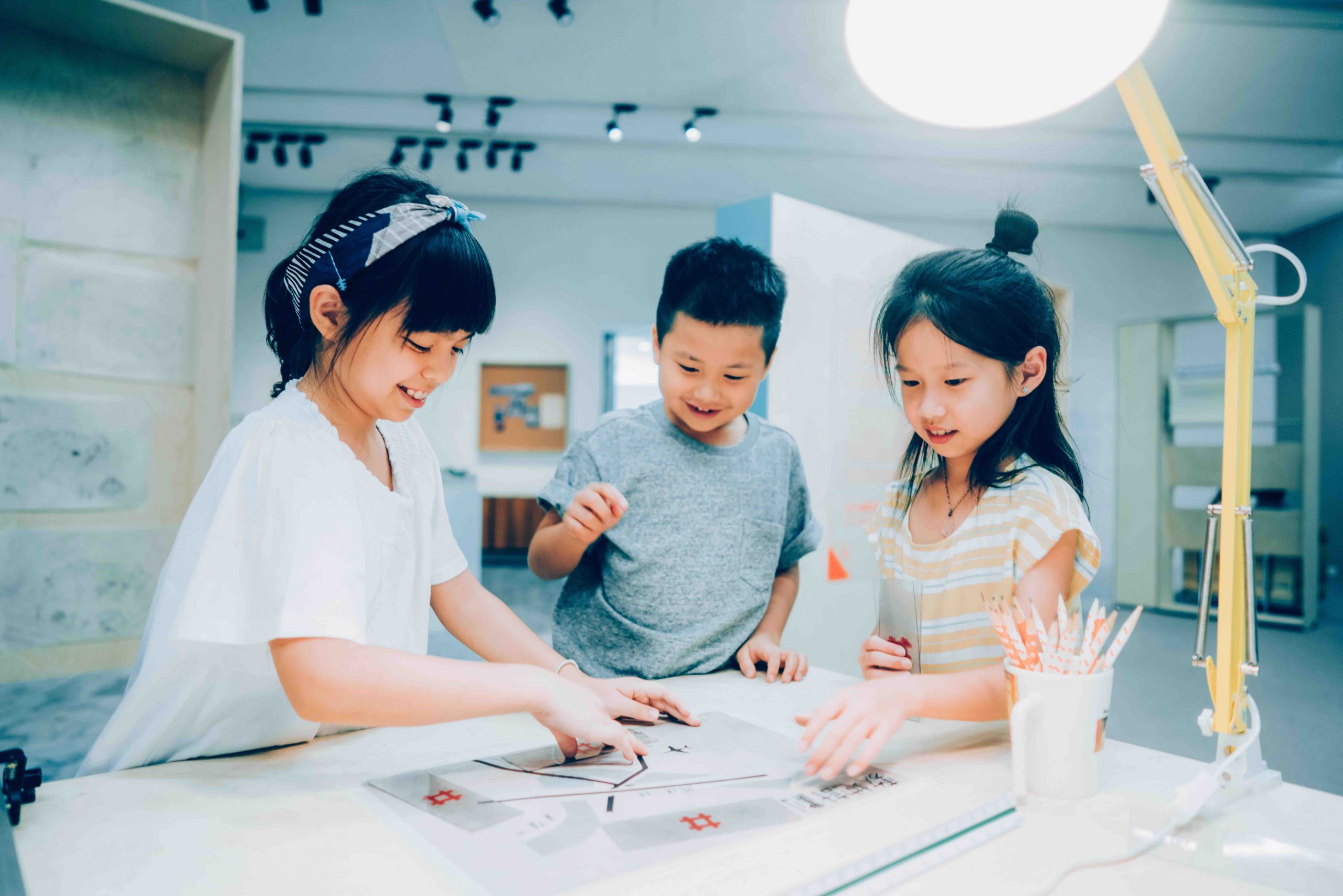 臺北市立美術館兒童教育藝術中心「建築的70％」三位孩童在共同操作展覽中的教具