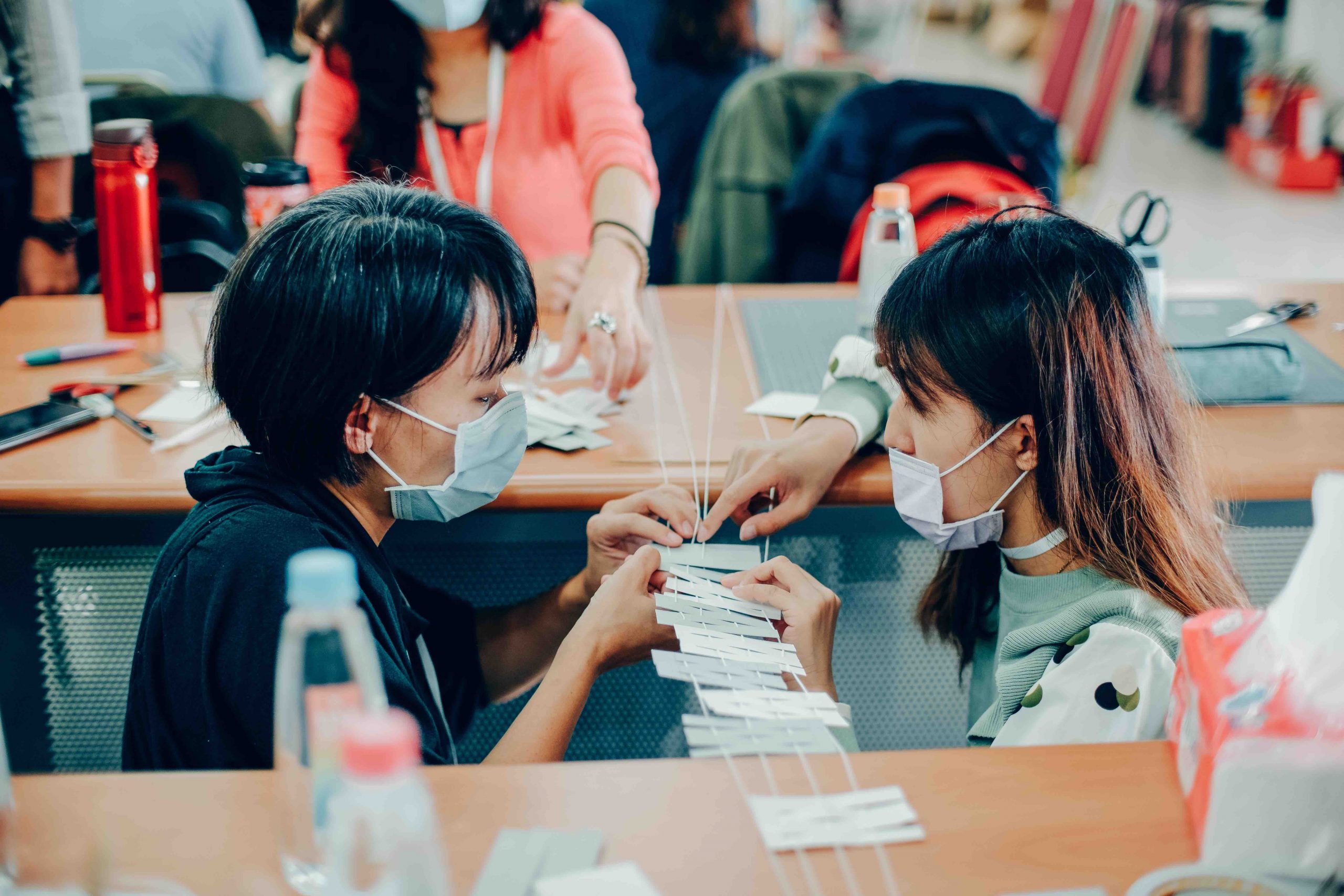 臺南構教師工作坊，兩名女教師蹲在模型前製作情況