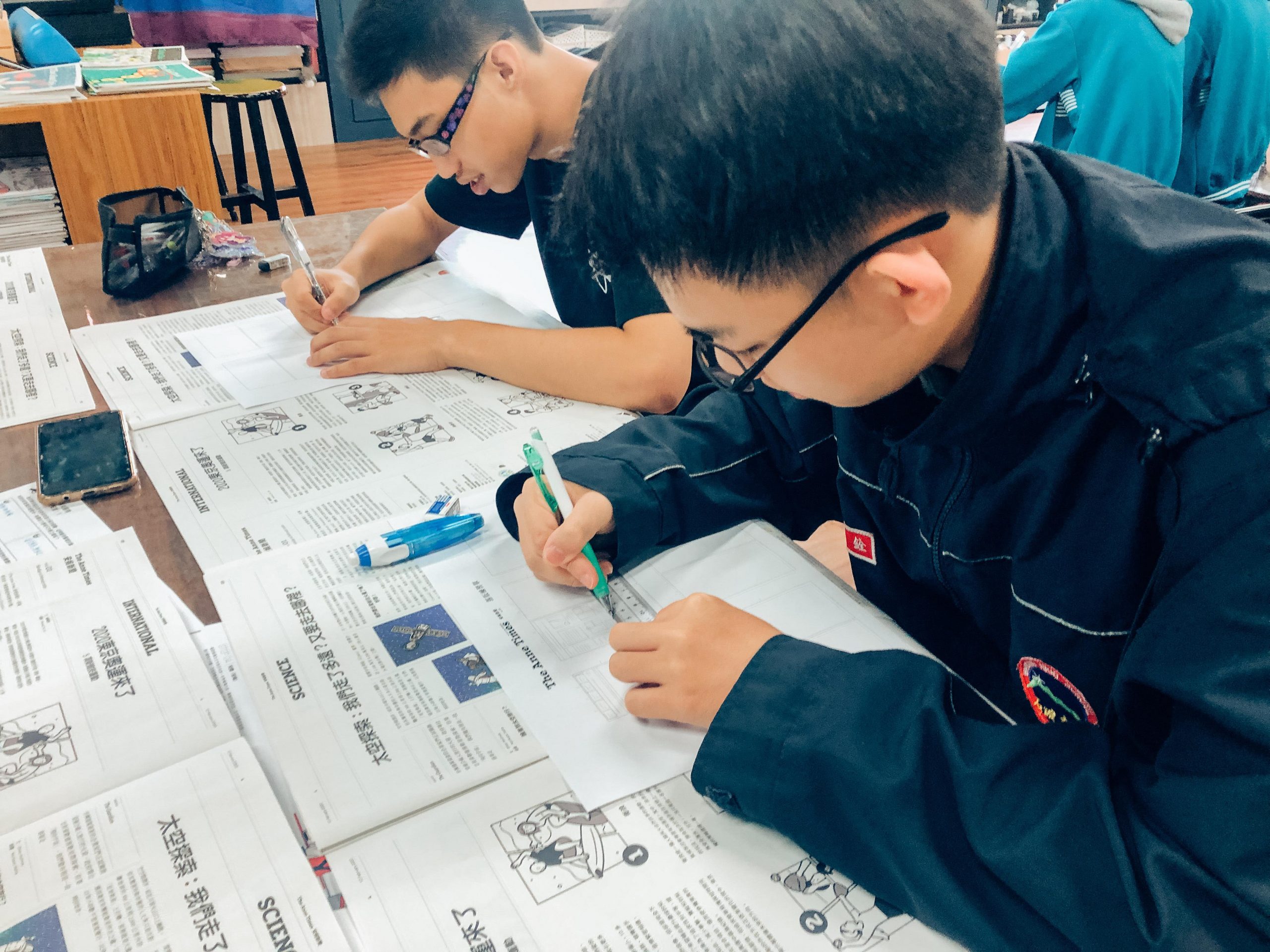 美感課程中兩名男同學在閱讀安妮新聞後寫上英文的學習單