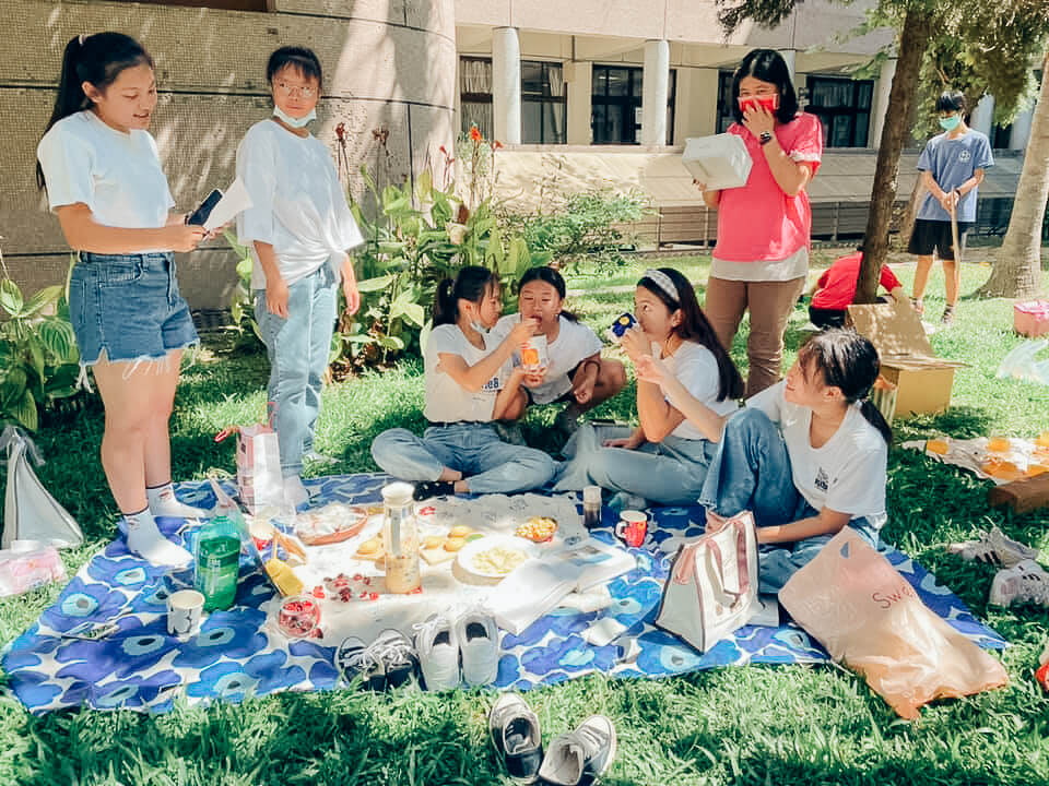 學生在草地上野餐討論擺盤跟食材